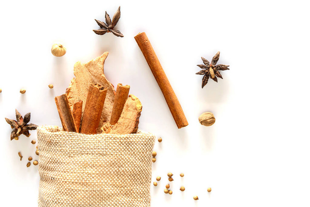 Cinnamon stick and dried ginger in sack with spices - Фото, изображение