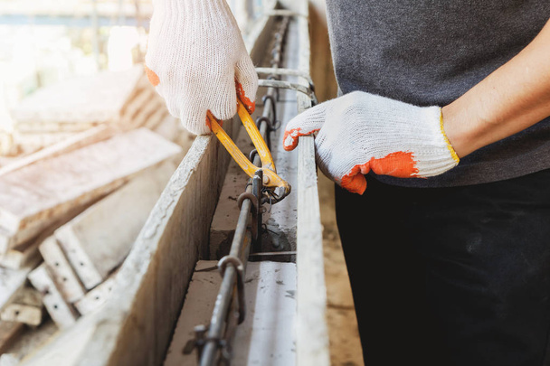 Kerpeten kullanarak el beton üzerine dökülür önce demir çelik tel bağlamak işçilerin yakın çekim. - Fotoğraf, Görsel