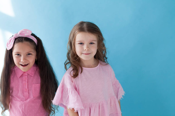 two little girls girlfriends together on blue background - Photo, Image
