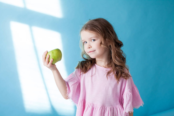 kis gyönyörű lány eszik almazöld fogak - Fotó, kép