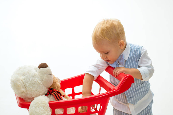 shopping for children. little boy go shopping with full cart. savings on purchases. happy childhood and care. little boy child in toy shop. It is bargain. Pleased with choice. How about price - Zdjęcie, obraz