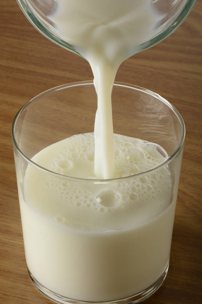 Pouring milk into a glass - Photo, Image