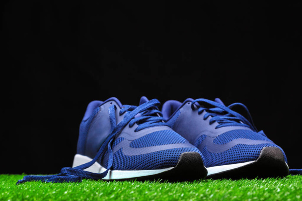 close up of Sport shoes on grass against black background  - Fotó, kép