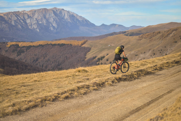 Otoño escena de montaña a caballo con una bicicleta de montaña equipada con bolsas de viaje
 - Foto, Imagen