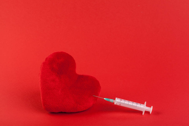 Red fabric toy heart and syringe, health concept - Foto, immagini