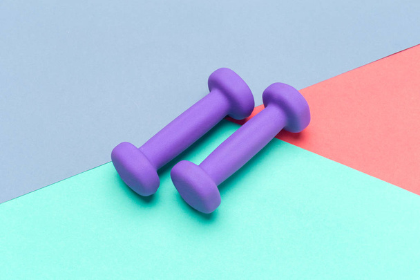 purple dumbbells on color background, sport concept   - Foto, imagen