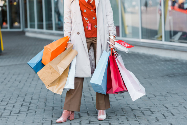 cropped view of female shopaholic with shopping bags and discount sign - Photo, Image