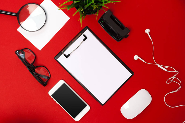 Flat lay of working space supplies on red background - Foto, imagen