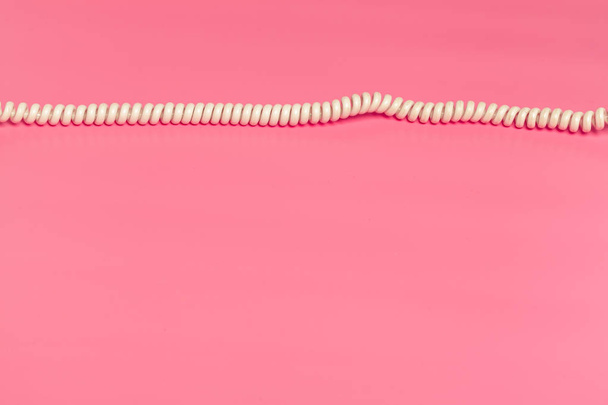 White telephone cord on bright pink background, top view - Photo, Image