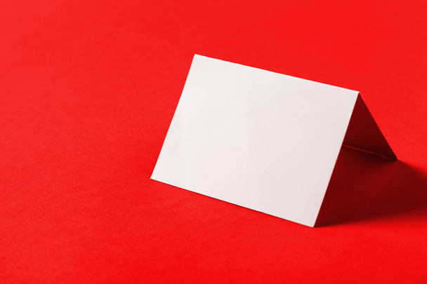 Blank white business card on red background - Фото, изображение