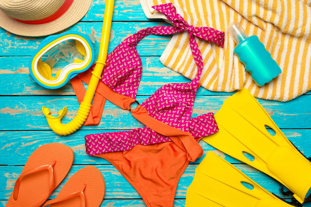 Composition with swimsuit on color wooden background - Fotó, kép