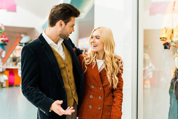 coppia sorridente parlare e trascorrere del tempo nel centro commerciale
 - Foto, immagini