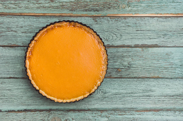 Fresh delicious homemade pumpkin pie on wooden background, top view. Space for text - Zdjęcie, obraz