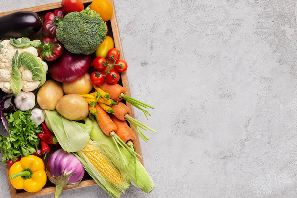 Verduras orgánicas frescas en caja de madera en gris
 - Foto, Imagen
