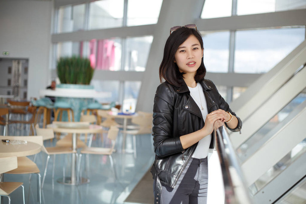 Lovely Asian girl in stylish casual clothes in a cafe. - Zdjęcie, obraz
