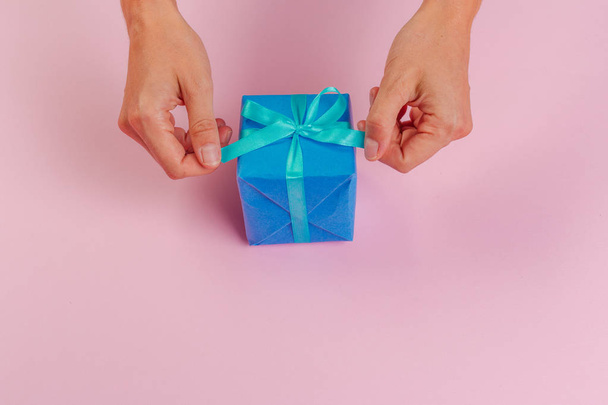 Woman holding gift box on color background - Foto, Imagen
