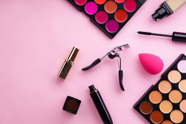 lipstick and concealer palettes with foundation and mascara with eyelash curler on pastel pink background, Makeup artist kit concept - Φωτογραφία, εικόνα