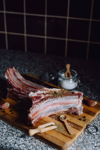  raw meat on wooden cutting board on dark background - Foto, Imagen