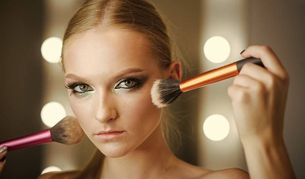 Makeup with powder brushes for young woman. Makeup model apply powder on skin - Photo, image