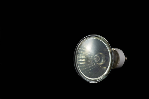 Halogen bulb of GU10 type on a black background with extensive copy space - Photo, Image