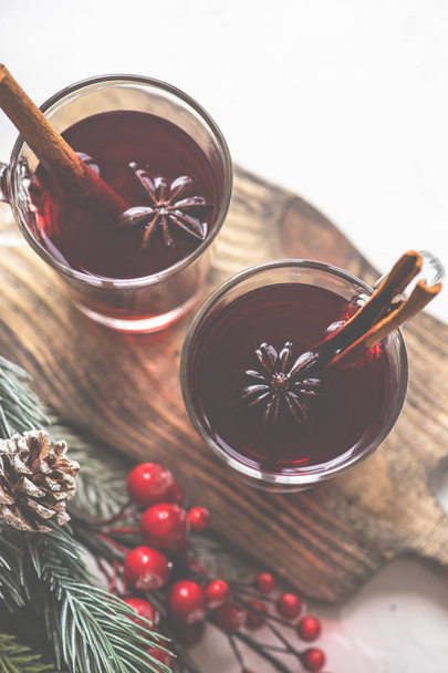 Tradizionale bevanda invernale vin brulè e decorazioni natalizie su sfondo bianco rustico
 - Foto, immagini
