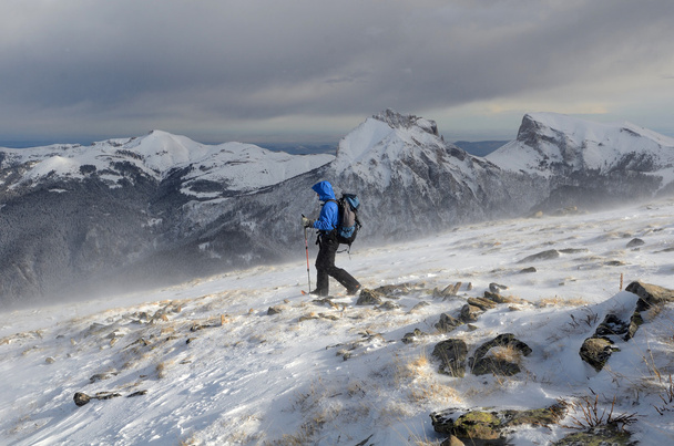 A man hiking in the winter mountains in stormy weather - Foto, Imagen