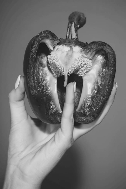 half of bell pepper in hand of woman, heart - Valokuva, kuva