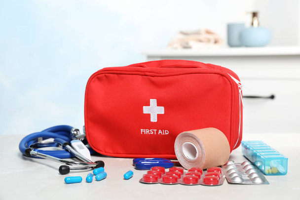 First aid kit with pills on table indoors - Fotoğraf, Görsel
