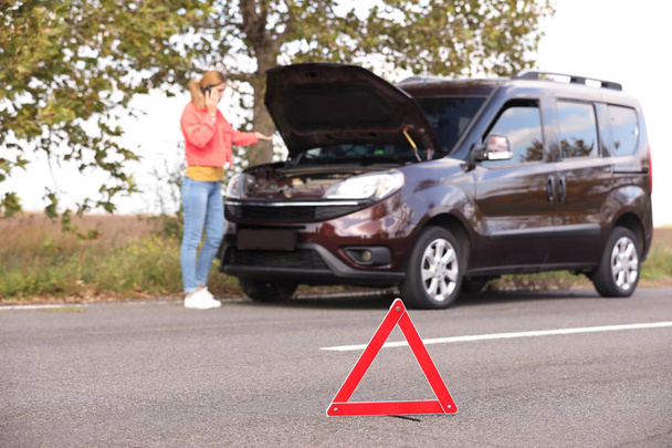 Emergency stop sign and driver near broken car on road. Auto insurance - Valokuva, kuva