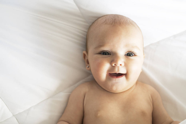 A Cute baby girl on a white bed at home - Photo, Image