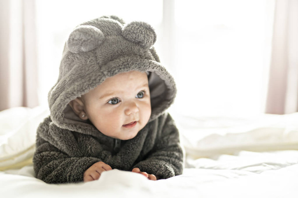 A Cute baby girl on a white bed at home - Фото, изображение