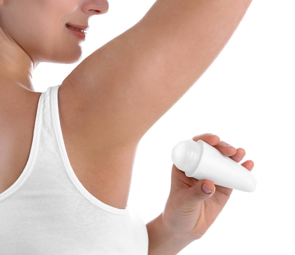 Young woman using deodorant on white background, closeup - Foto, afbeelding