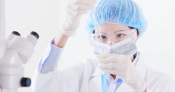 nainen tiedemies ottaa koeputki laboratoriossa
 - Valokuva, kuva