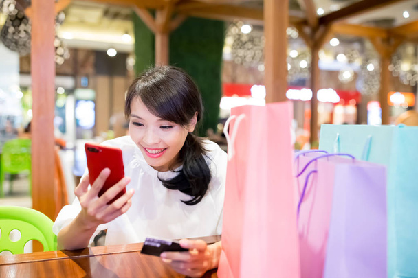 Frau benutzt Telefon und Kreditkarte im Restaurant - Foto, Bild
