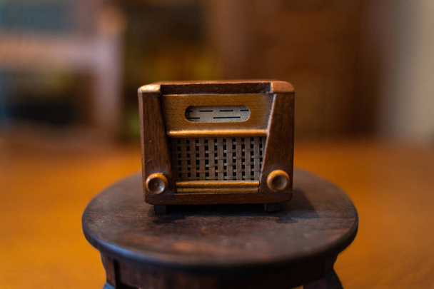 Старое радио куклы стоит на маленьком кукольном столе
 - Фото, изображение