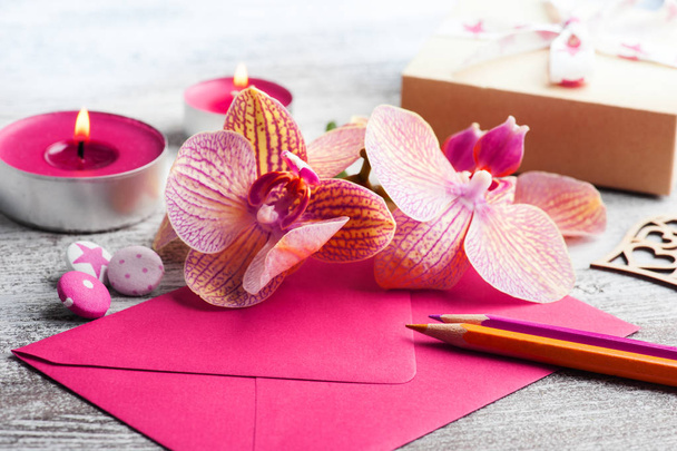Orquídeas, sobre púrpura y caja de regalo artesanal sobre un fondo de madera
 - Foto, Imagen