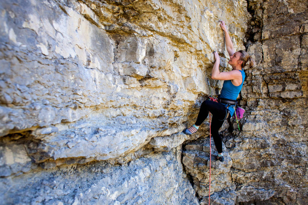 若い女性は岩、自然にアクティブな残りの部分に登山します。 - 写真・画像