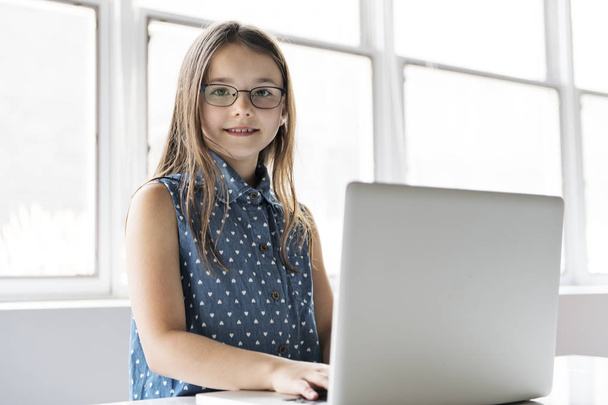Egy fiatal lány laptopot használ az iskolában. - Fotó, kép