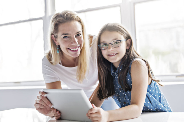 Schoolgirl researching online with the guidance of her teacher - Zdjęcie, obraz