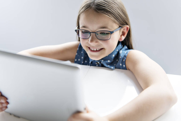 Ένα χαριτωμένο παιδί που χρησιμοποιεί tablet στο σχολείο - Φωτογραφία, εικόνα