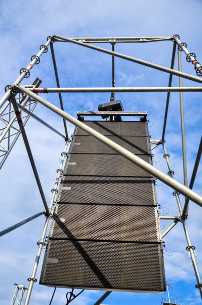 Concert sound system on metal structures at height outdoor against the blue sky - Photo, Image