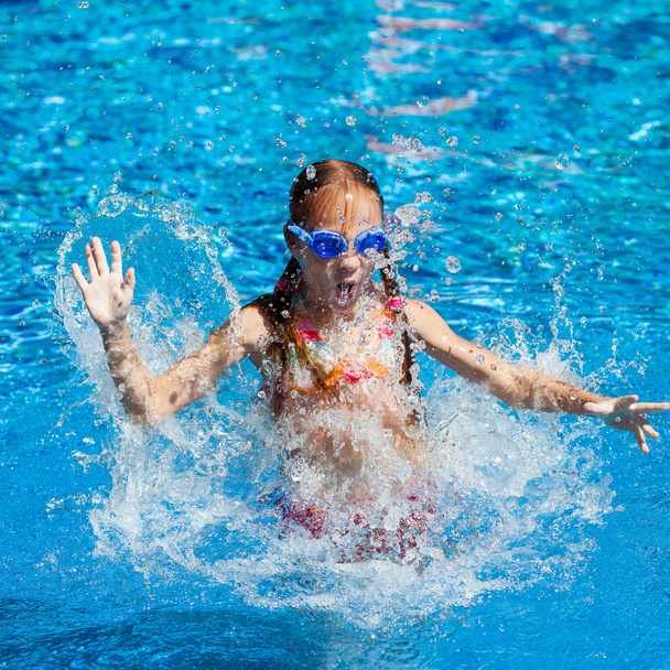 happy little girl splashing around in the pool - Foto, Bild