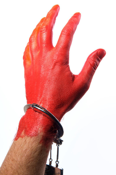 Atrapado con las manos en la masa roja pintado a mano usando esposas concepto
 - Foto, Imagen