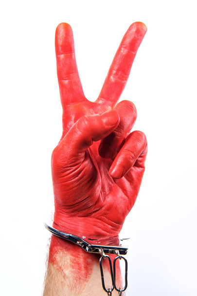 Rote Hand erwischt - rot lackierte Hand mit Handschellen - Foto, Bild