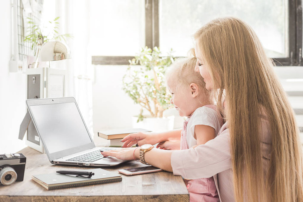 Fiatal üzletasszony munka otthon mögött a laptop egy kisgyermek. Kreatív skandináv stílusú munkaterület. Munka a szülési szabadság - Fotó, kép