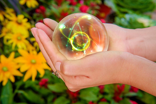Eller kristal top atomik parçacık çiçek ile arka planda tutun. - Fotoğraf, Görsel