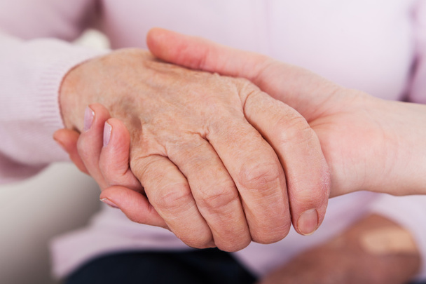 Young Woman Holding Senior Woman's Hand - Photo, Image