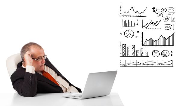 businessman sitting at desk with graphs and laptop - Φωτογραφία, εικόνα