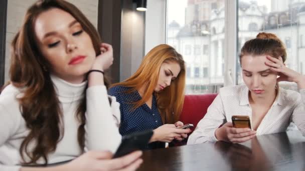 Tres mujeres jóvenes en el lugar de narguile sentadas en sus teléfonos. Retrato
 - Metraje, vídeo