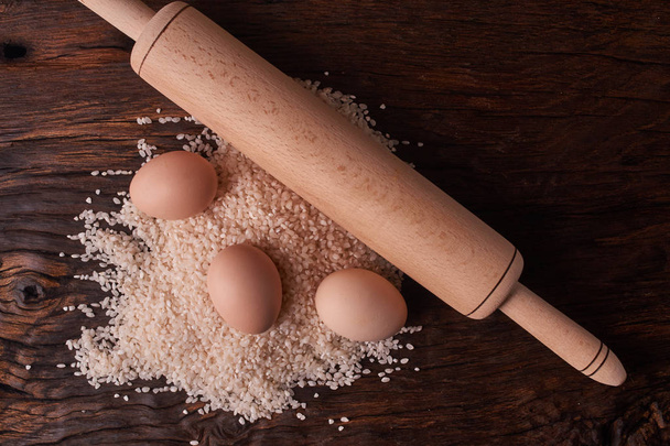 Групування рису і не виділених яєць і боротьба з дерев'яним столом. Концепція здорового харчування
 - Фото, зображення